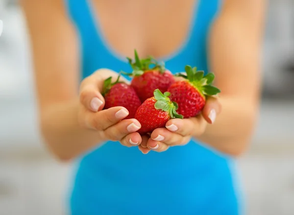 Gros plan sur une jeune femme montrant des fraises — Photo
