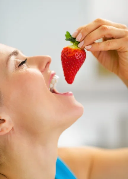 Portret van een jonge vrouw eten aardbei — Stockfoto