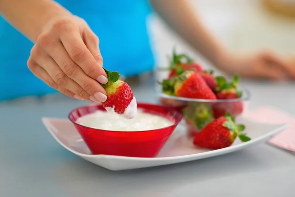 Nahaufnahme einer glücklichen jungen Frau, die Erdbeere mit Joghurt in Ki isst — Stockfoto