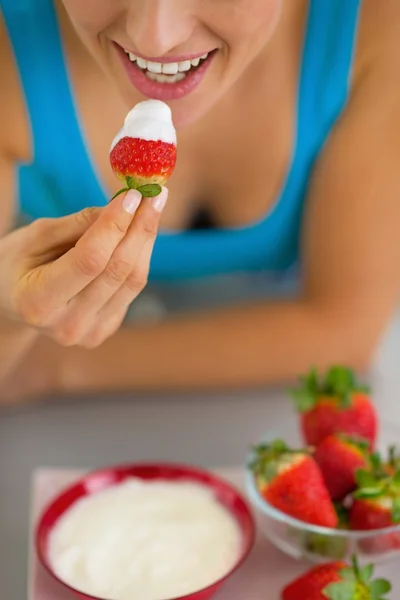 Nahaufnahme einer glücklichen jungen Frau, die Erdbeere mit Joghurt in Ki isst — Stockfoto
