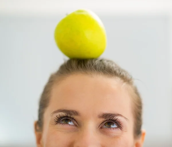 Primer plano de la mujer joven con manzana en la cabeza — Foto de Stock