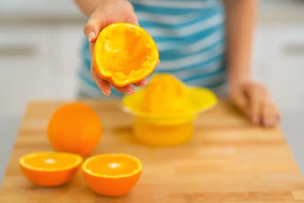 Closeup on young woman showing orange peel after squeezing juice — Stock Photo, Image