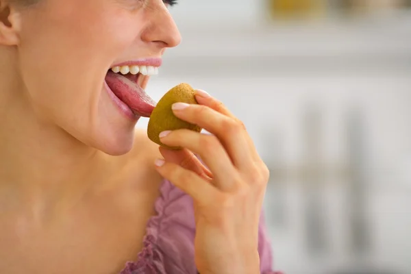 Nahaufnahme einer jungen Hausfrau, die Kiwi isst — Stockfoto