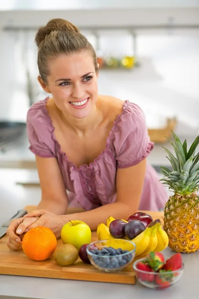 Portrait of smiling young housewife with fruits in modern kitche — Stock Photo, Image