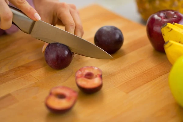 Closeup on young housewife cutting plums — Stock Photo, Image
