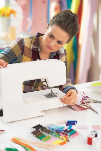 Красива жінка, що працює з швейною машиною — стокове фото