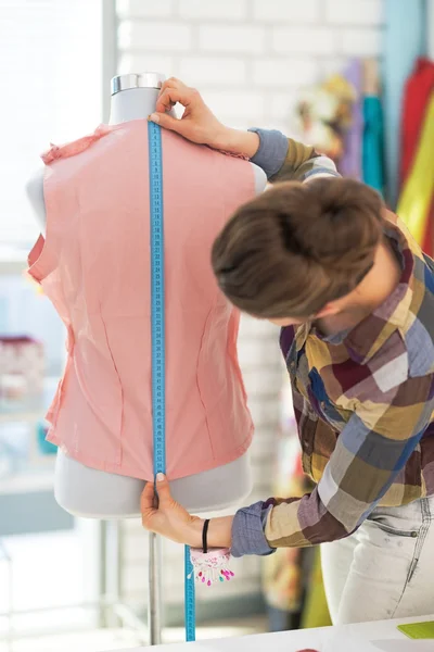 Kleermaker vrouw die werkt met jurk in studio. Achteraanzicht — Stockfoto