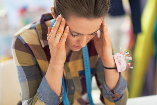 Portrait of stressed tailor woman at work