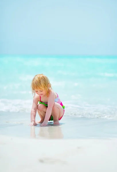 Baby girl playing on sea coast — Stock Photo, Image