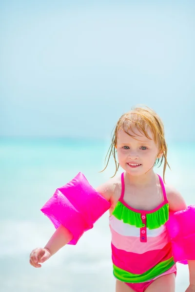 Dziewczynka w nadmuchiwane opaska spacery nad morzem — Zdjęcie stockowe