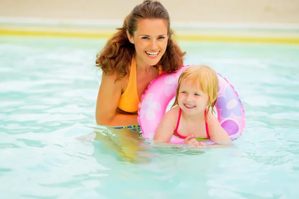 Portrait of happy mother and baby girl with swim ring swimming i — Stock Photo, Image