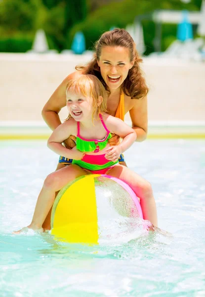 Portret szczęśliwy matka i dziecko dziewczynka gra z piłka plażowa i — Zdjęcie stockowe