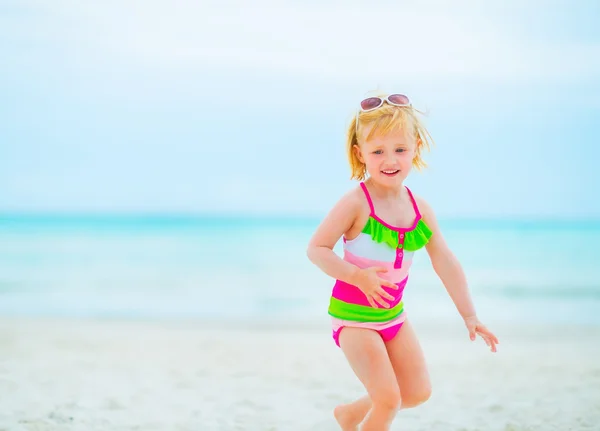 Menina bebê em óculos de sol jogando na praia — Fotografia de Stock