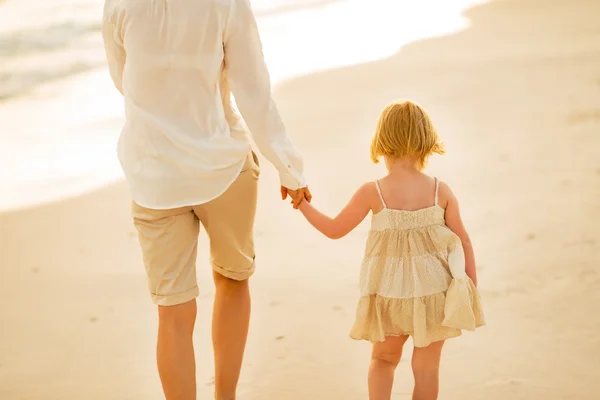 Nahaufnahme von Mutter und Baby, die am Abend am Strand spazieren gehen. — Stockfoto