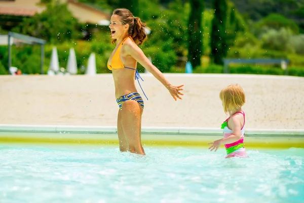 Mère et bébé fille jouer dans la piscine — Photo