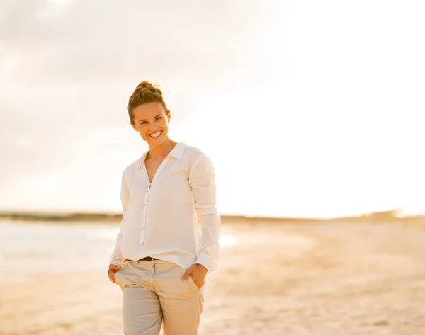 Porträt einer glücklichen jungen Frau am Strand am Abend — Stockfoto