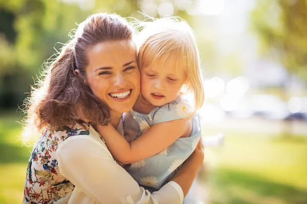 Porträt einer glücklichen Mutter und eines kleinen Mädchens, die sich umarmen — Stockfoto