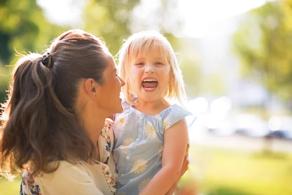 Portret van lachende moeder en babymeisje buitenshuis — Stockfoto