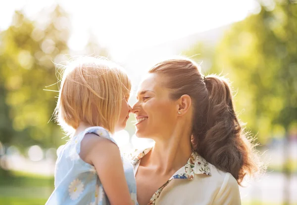 Porträt einer glücklichen Mutter und eines kleinen Mädchens im Freien — Stockfoto
