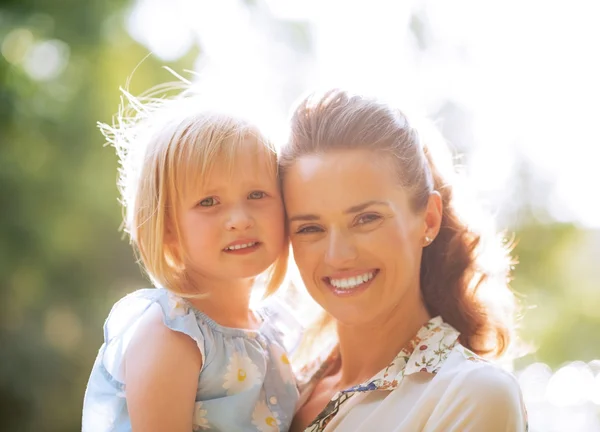 Portrait of happy mother and baby girl outdoors in park — Stock Photo, Image