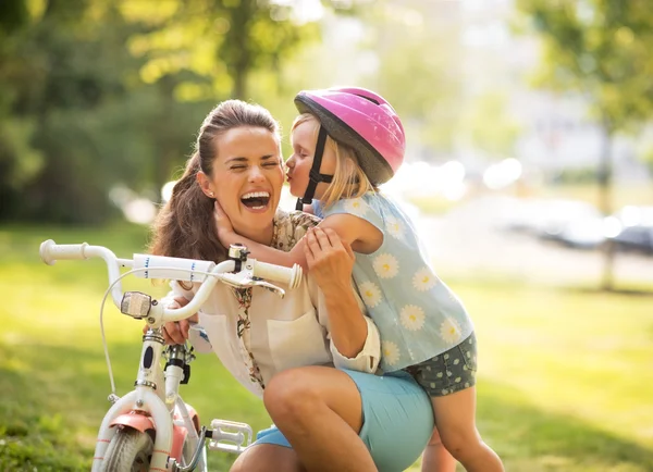 Boldog anya és baba lány szórakozás a parkban a kerékpár — Stock Fotó