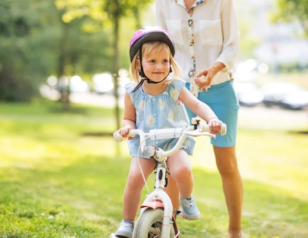 Matka i dziecko dziewczynka jazda rowerem na zewnątrz — Zdjęcie stockowe