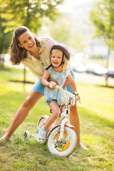 Porträtt av mor och baby flicka med cykel — Stockfoto
