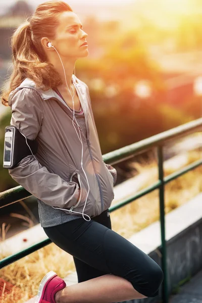 Portrait of relaxed fitness young woman in city in the evening — Stock Photo, Image