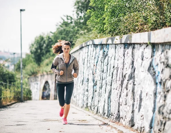 Celovečerní portrét mladé ženy fitness, jogging v městě — Stock fotografie