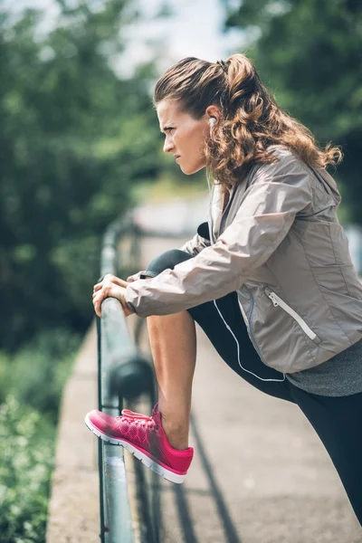 Fitness fiatal nő, nyúlik a Városligetben — Stock Fotó