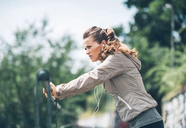 Ung kvinna fitnessutövaren i stadsparken — Stockfoto