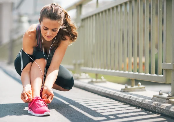 Fitness joven mujer atando cordones en la ciudad — Foto de Stock