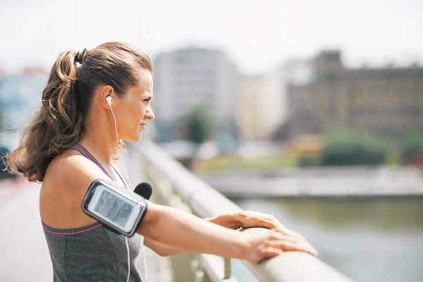 Mujer joven fitness en la ciudad mirando a la distancia — Foto de Stock