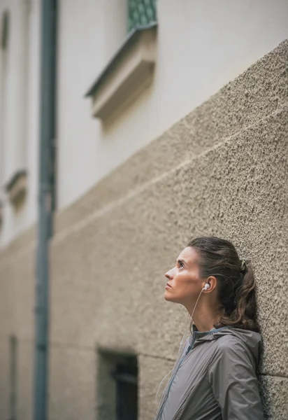 Retrato de fitness jovem mulher ouvindo música ao ar livre — Fotografia de Stock