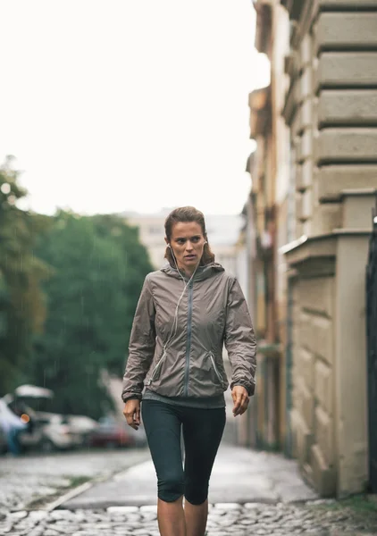 Fitness mladá žena chůze venku v deštivé city — Stock fotografie