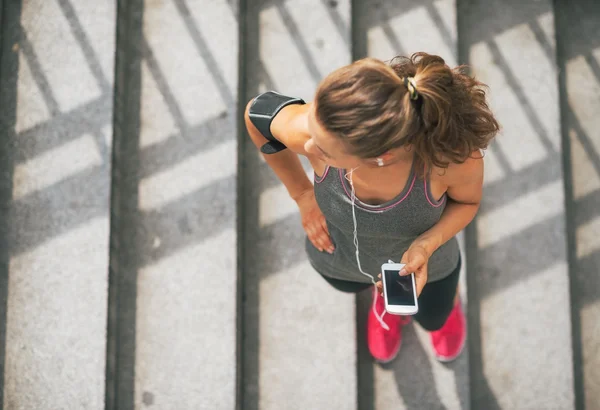 Portrait of fitness young woman with cell phone outdoors in the — Stock Photo, Image