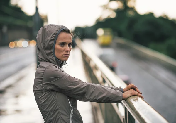 Retrato de la mujer joven fitness mirando a la distancia en c lluvioso — Foto de Stock