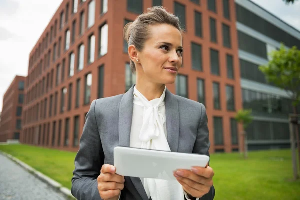 Деловая женщина с планшетным ПК перед офисным зданием — стоковое фото