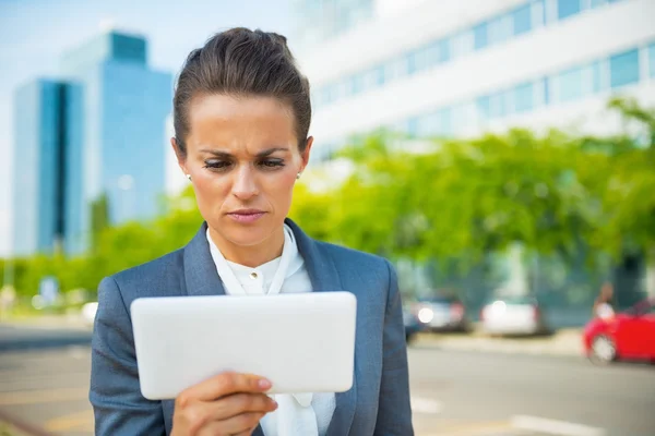 Serious business woman using tablet pc in office district — Zdjęcie stockowe