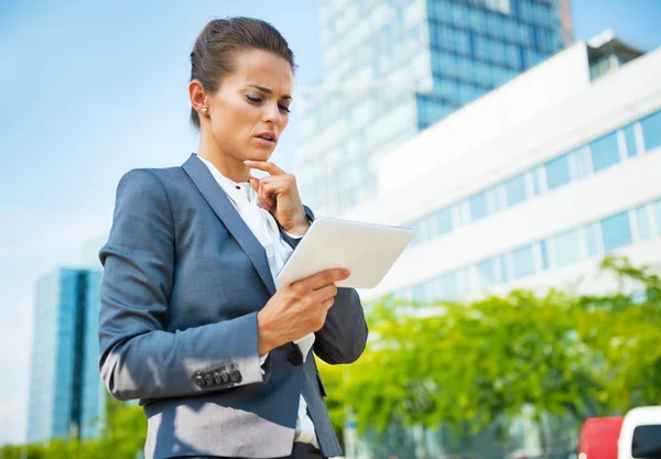 Thoughtful business woman with tablet pc in office district — 图库照片