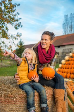 mutlu anne ve haystack kabaklar ve POI ile oturan çocuk