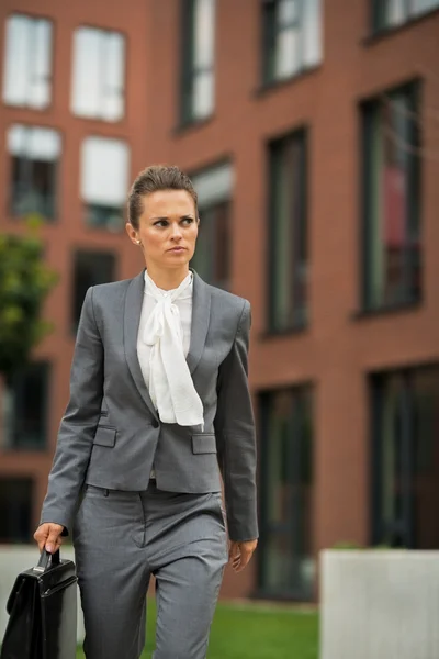 Business woman with briefcase walking in business district — Stockfoto