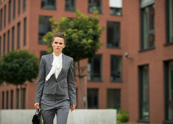 Business woman with briefcase walking in business district — Stock fotografie