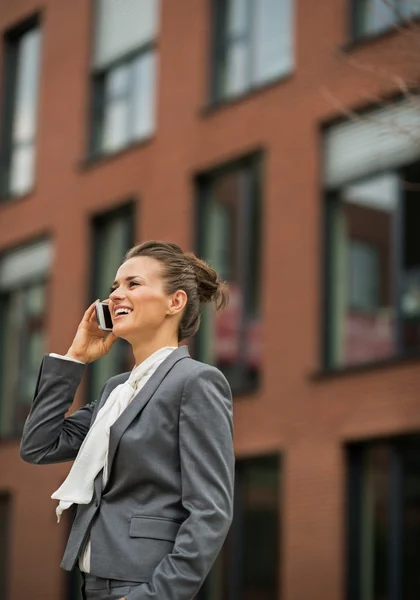 Zufriedene Geschäftsfrau telefoniert vor Bürogebäude — Stockfoto