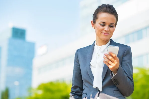 Business woman with cell phone in office district — Stok fotoğraf