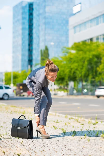 Business woman with briefcase in office district having pain in — Zdjęcie stockowe