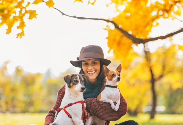 Retrato de una joven sonriente con perros al aire libre en otoño —  Fotos de Stock