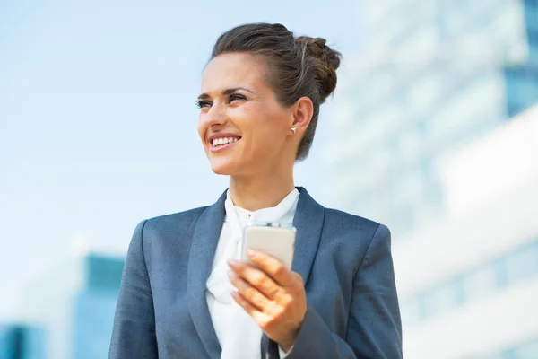 Business woman with cell phone in office district — Stok fotoğraf