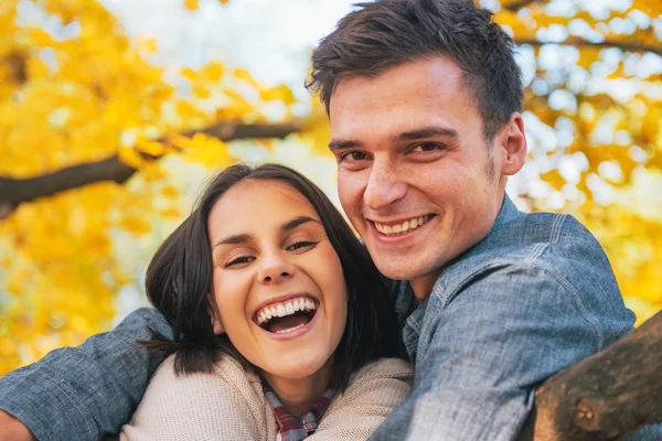 Porträt eines lächelnden jungen Paares im Herbst — Stockfoto