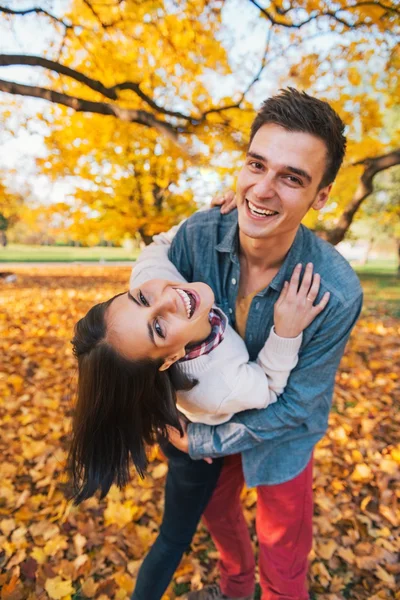 Retrato de feliz jovem casal ao ar livre no parque no outono ter — Fotografia de Stock